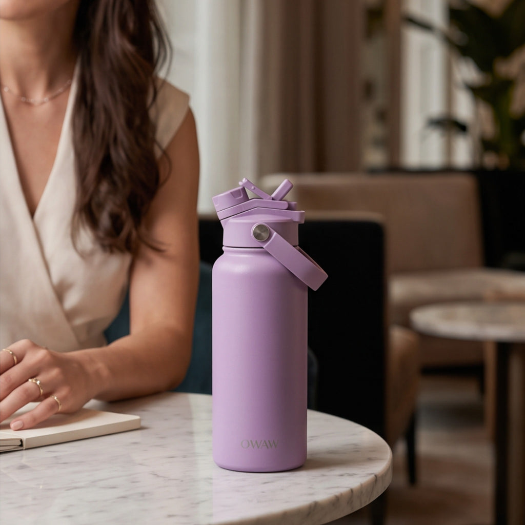 OWAW Nomade stainless steel water bottle in Lavender on a marble café table
