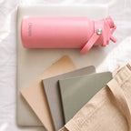 OWAW Nomade stainless steel water bottle in Pink on a laptop with notebooks and a canvas tote
